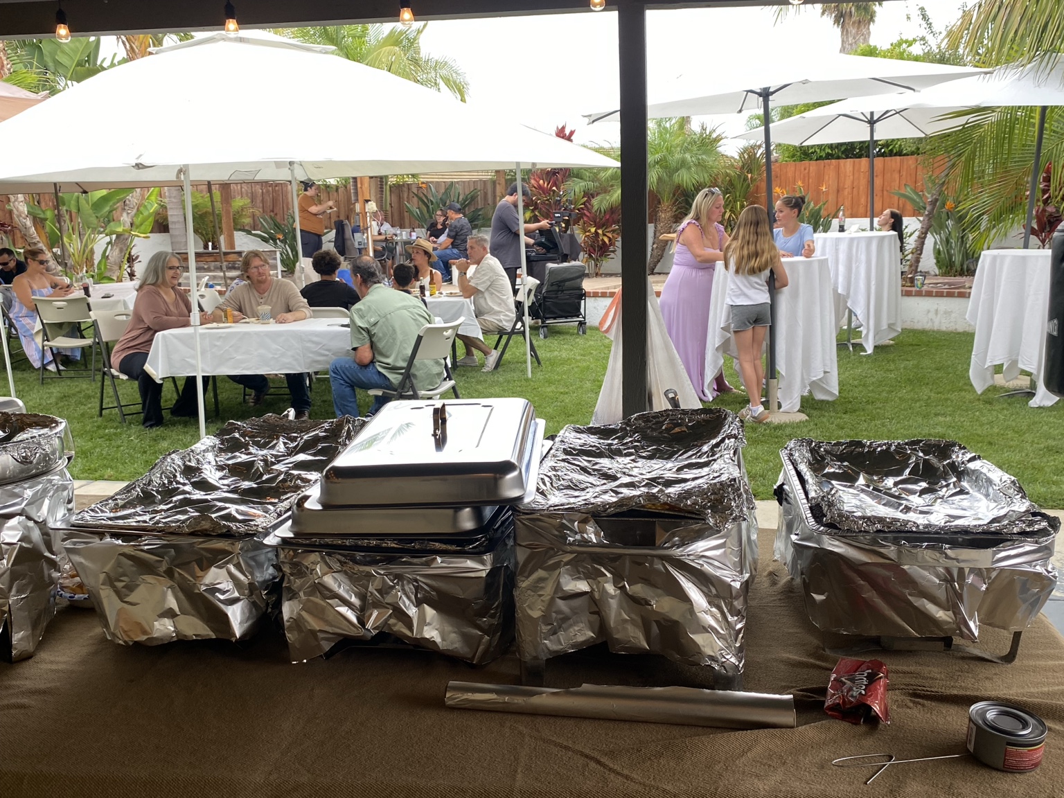 Guests at an O'SIDE BBQ MAN catered backyard gathering with buffet service